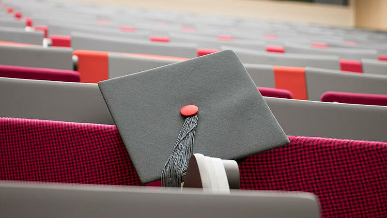 Doctoral hat on empty auditorium seats