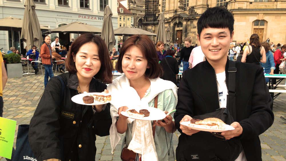 Three people tasting dishes done by our PhD students