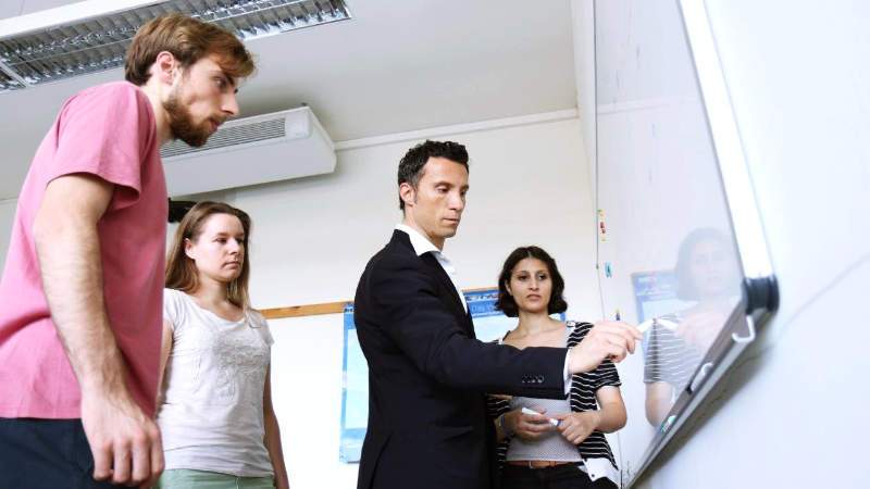 Cannistraci and three group members in front of a whiteboard