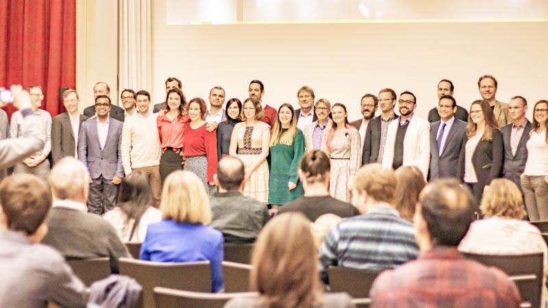 Groupshot of graduates and group leaders in front of the audience