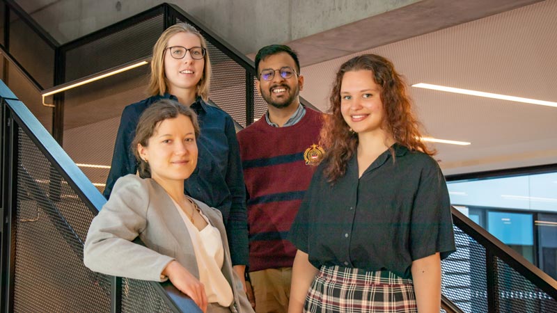 Four young people on stairs in a modern scientific institutes